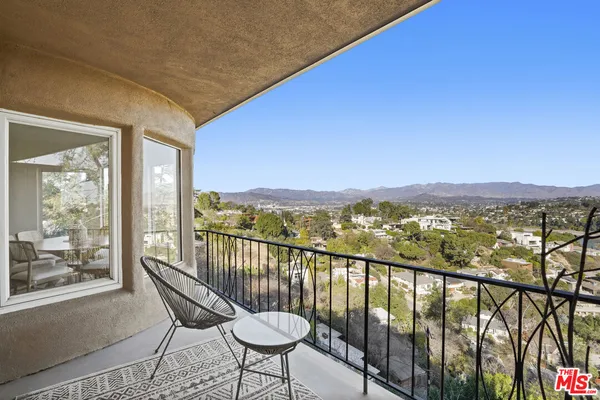 a view of a city from a balcony with furniture