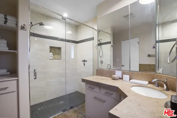 a bathroom with a double vanity sink mirror and shower