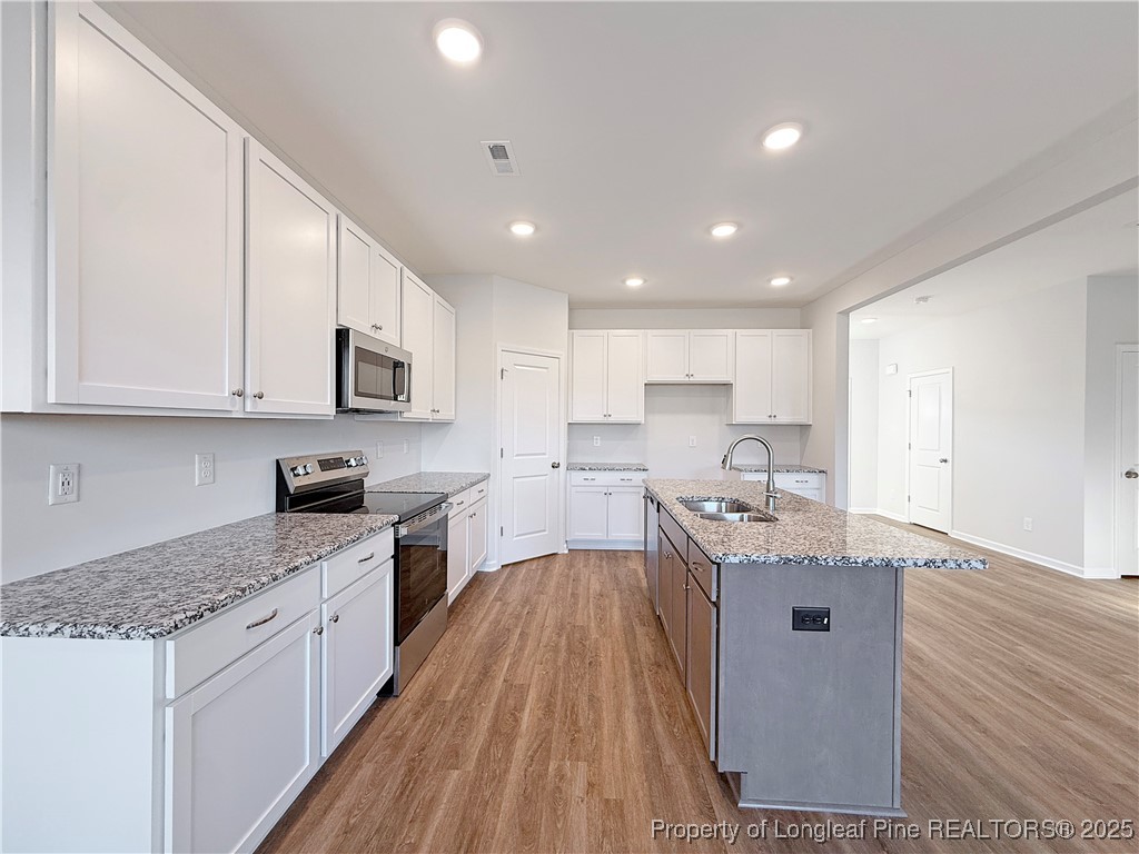 514 Ashley Heights Raeford, NC 28376 - Photo 11 of 39 a kitchen with stainless steel appliances granite countertop wooden cabinets granite counter tops and a hard wood floors