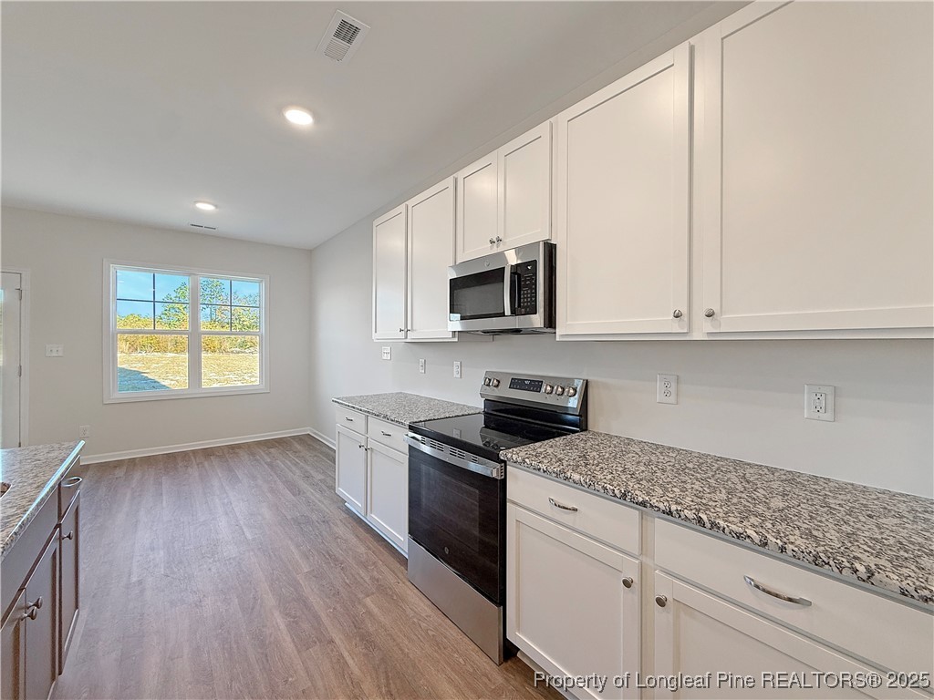514 Ashley Heights Raeford, NC 28376 - Photo 12 of 39 a kitchen with granite countertop a stove a sink and a microwave