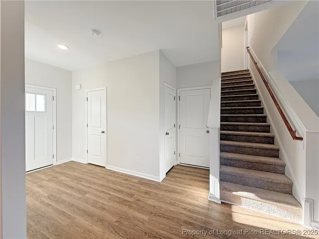 a view of a room with wooden floor and white walls