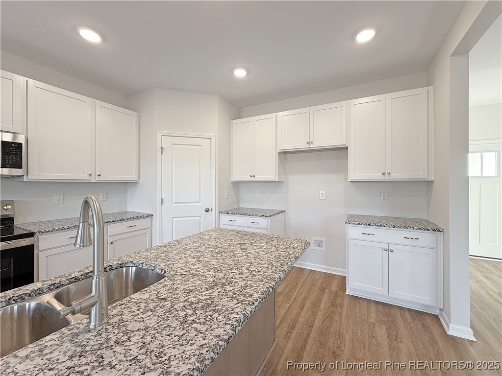 514 Ashley Heights Raeford, NC 28376 - Photo 8 of 39 a kitchen with granite countertop a stove top oven sink and cabinets