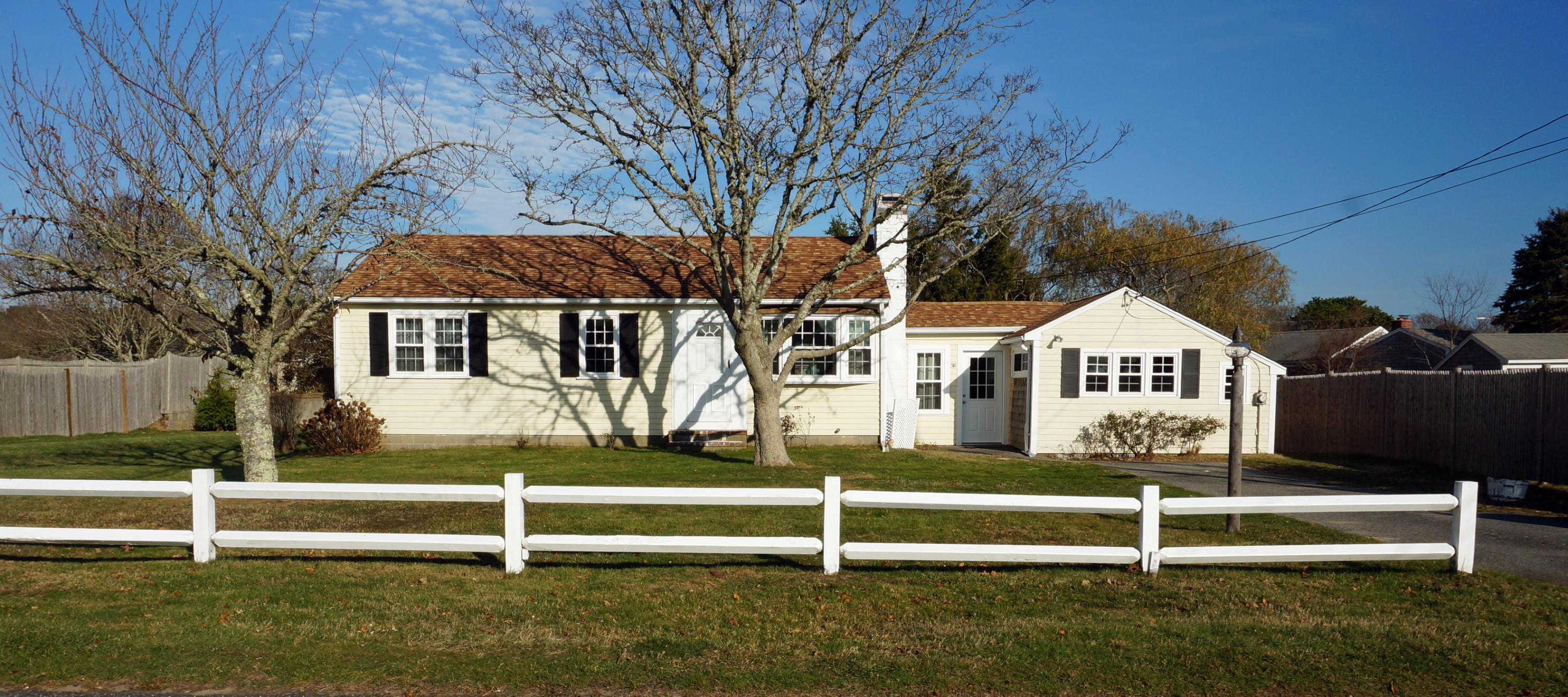 98 Iroquois Boulevard West Yarmouth, MA 02673 - Photo 1 of 34 a white house that has a tree in front of it