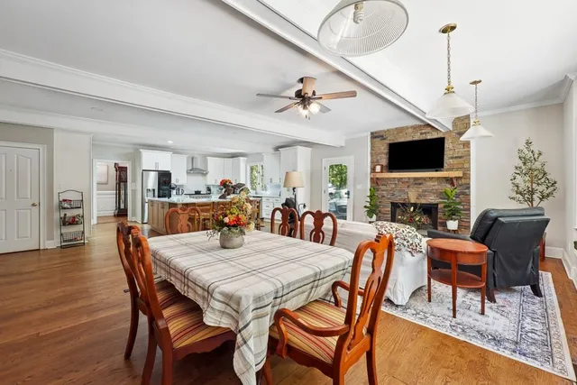 a view of a dining room with furniture a fireplace and wooden floor
