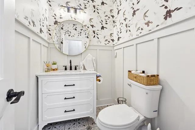 a bathroom with a sink mirror vanity and toilet
