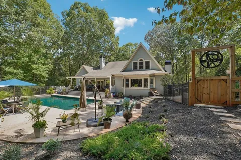 a view of a house with backyard water fountain and sitting area