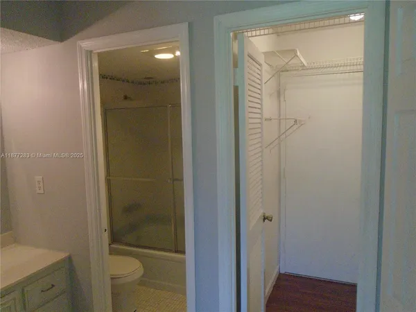 a bathroom with a granite countertop sink a toilet and shower