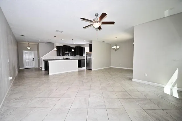 a view of a livingroom with kitchen and a window