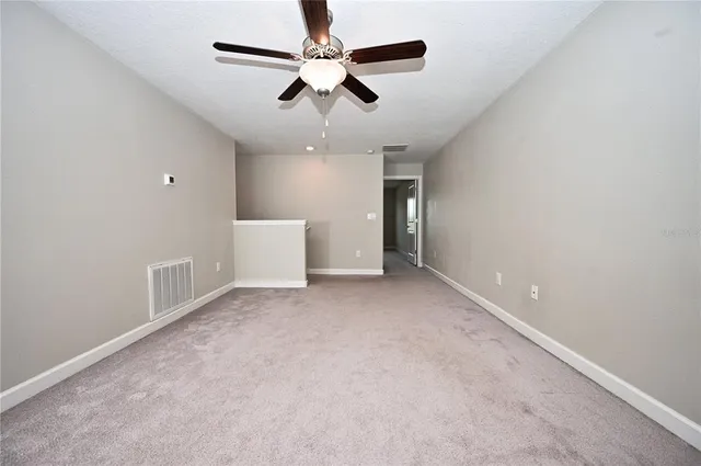 en empty room with ceiling fan and window