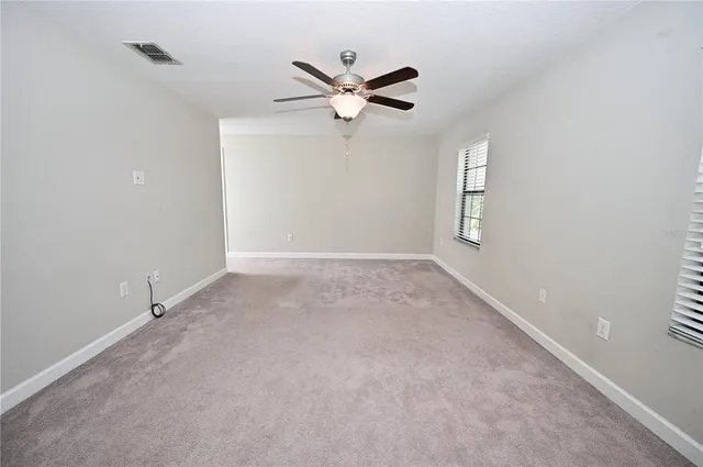 a view of a livingroom with a ceiling fan and window