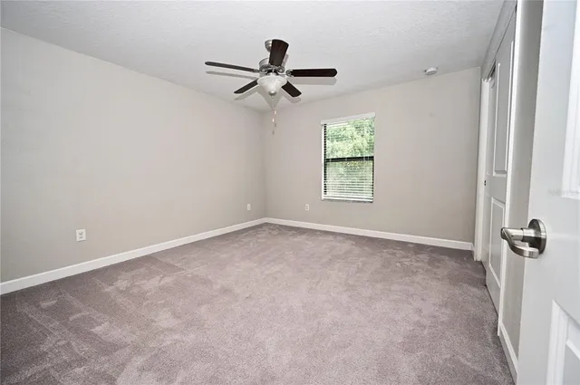 a view of empty room with ceiling fan