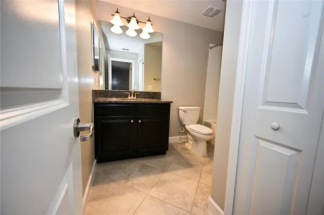 a bathroom with a sink vanity mirror and toilet