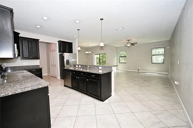 a large kitchen with granite countertop a sink and cabinets