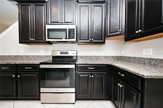 a kitchen with granite countertop wood cabinets and stainless steel appliances