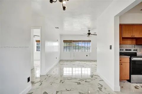 a view of a hallway with wooden cabinet and a living room