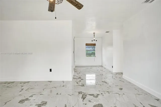 a view of a refrigerator in kitchen and an empty space in the view
