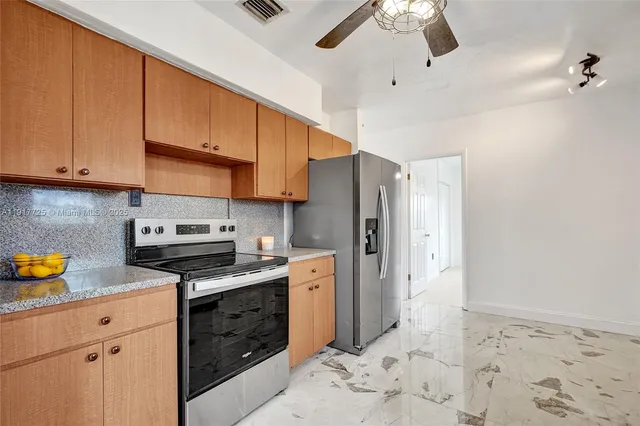 a kitchen with stainless steel appliances a stove a sink and cabinets