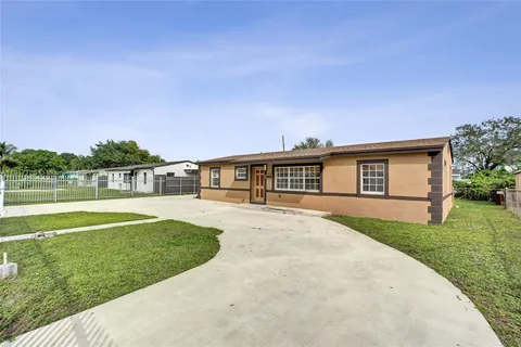 a front view of a house with a yard and trees