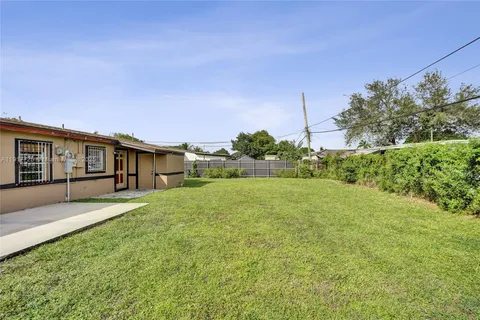 a view of a backyard with potted plants and large tree