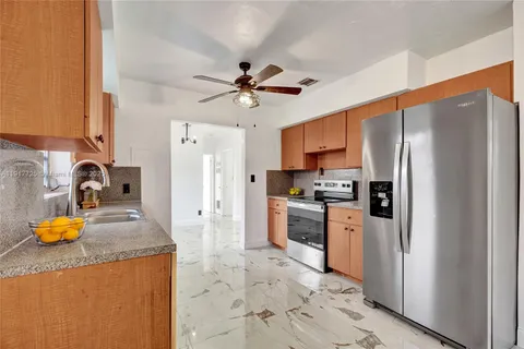 a kitchen with stainless steel appliances granite countertop a refrigerator a stove and a sink
