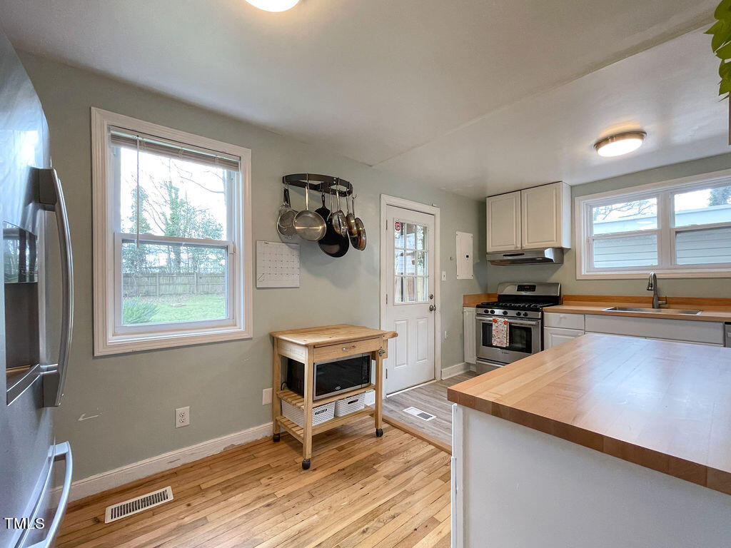 301 Colleton Road Raleigh, NC 27610 - Photo 4 of 14 a kitchen with a refrigerator and a stove top oven