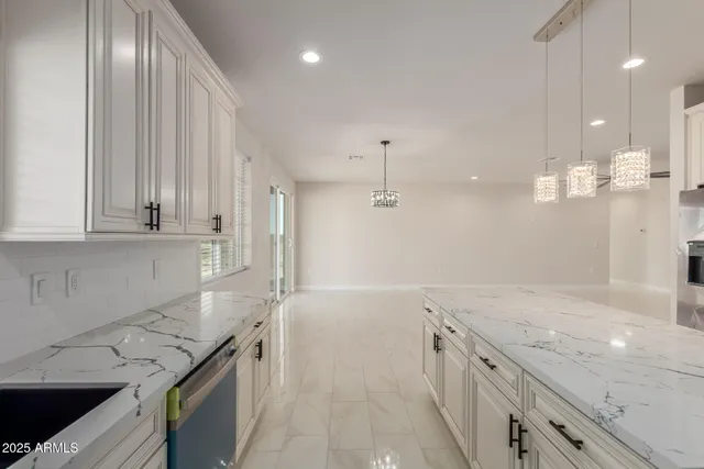 a kitchen with stainless steel appliances kitchen island granite countertop a sink a stove and cabinets