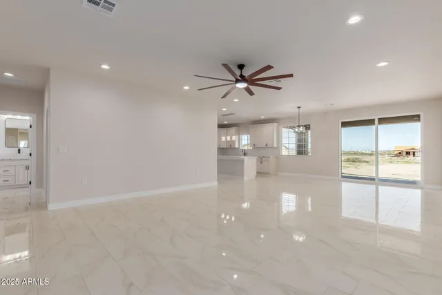 an empty room with a ceiling fan and a window