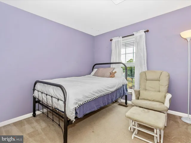 a bedroom with a bed chair and a window