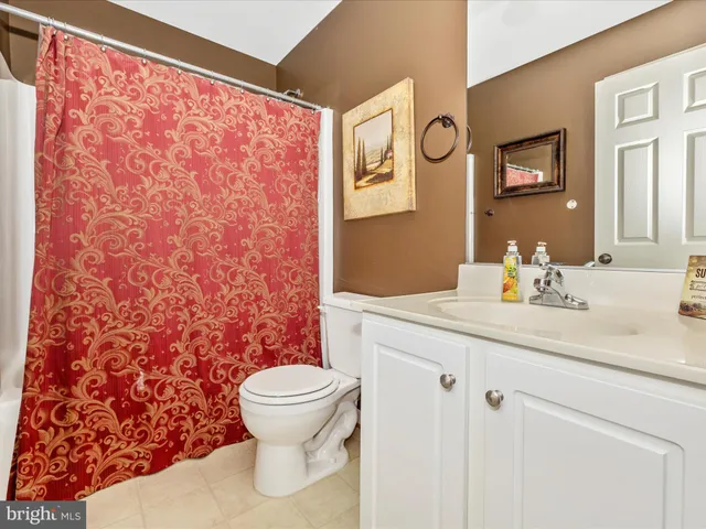 a bathroom with a granite countertop sink toilet and a mirror