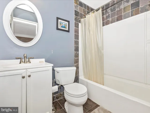 a white toilet sitting next to a bathroom sink and tub