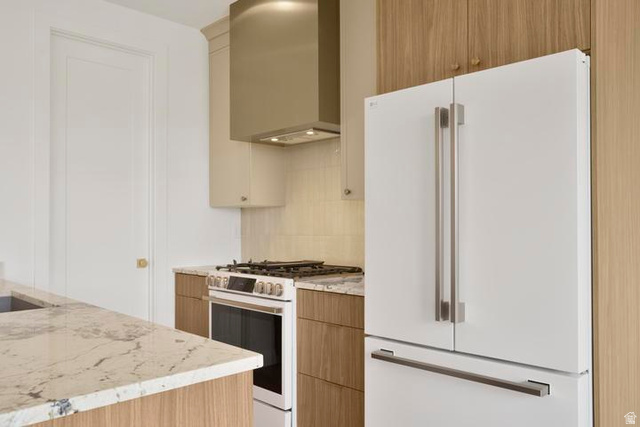 990 Manen Street Washington, UT 84780 - Photo 7 of 43 Kitchen featuring a white French-door refrigerator, stainless steel range with matching hood, light-toned wood-finish cabinetry, and veined stone countertops