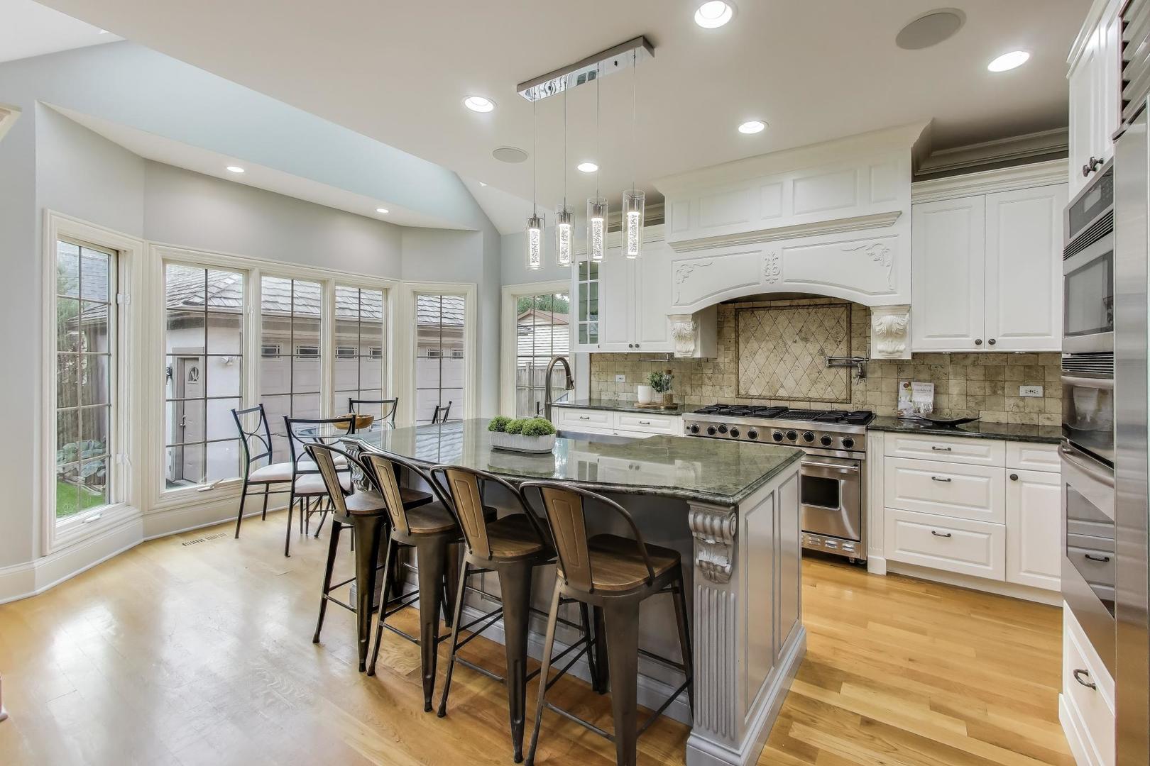 621 North County Line Road Hinsdale, IL 60521 - Photo 11 of 59 a kitchen with stainless steel appliances a dining table chairs stove and cabinets