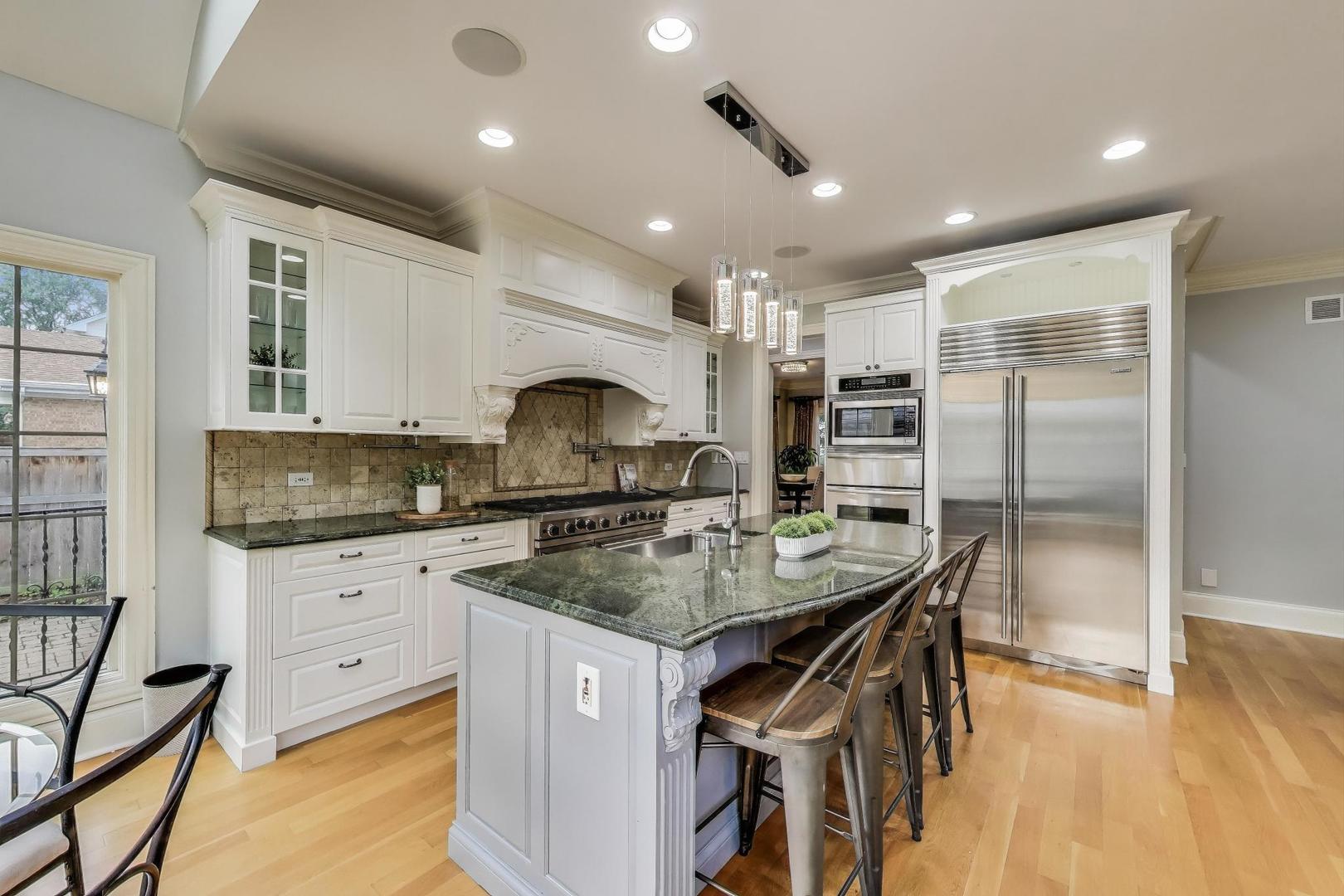 621 North County Line Road Hinsdale, IL 60521 - Photo 12 of 59 a kitchen with stainless steel appliances granite countertop a sink a stove a refrigerator cabinets and living room view