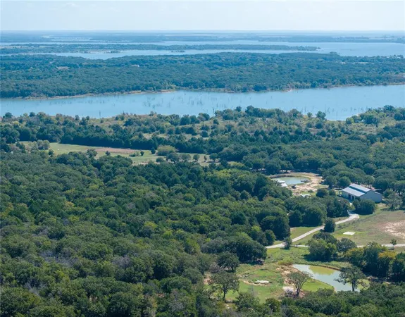 an aerial view of residential house with outdoor space and lake view
