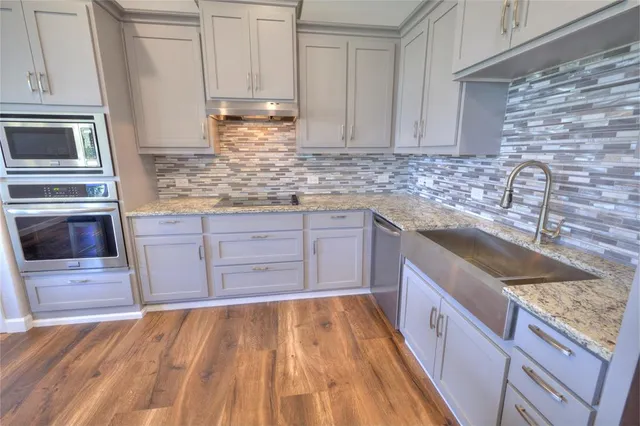 a kitchen with granite countertop a sink and cabinets