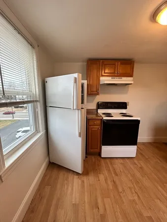 a kitchen with a refrigerator sink and wooden floor