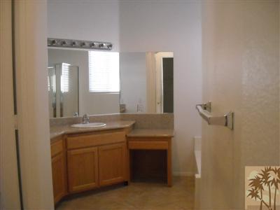 49829 Wayne Street Indio, CA 92201 - Photo 18 of 24 a bathroom with a double vanity sink a toilet and a mirror