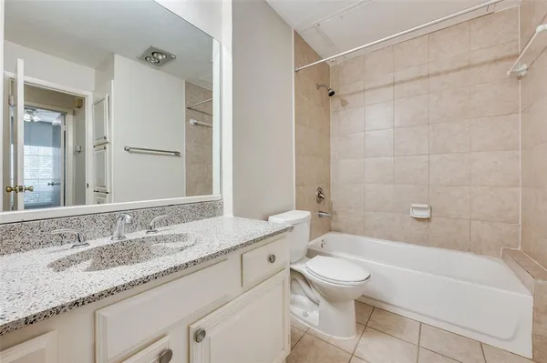 a bathroom with a granite countertop sink a toilet and shower