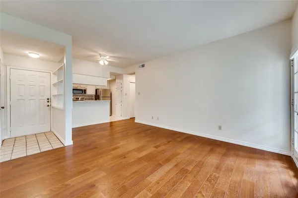 a view of empty room with wooden floor