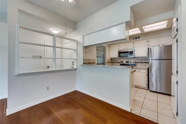 a kitchen with white cabinets and stainless steel appliances