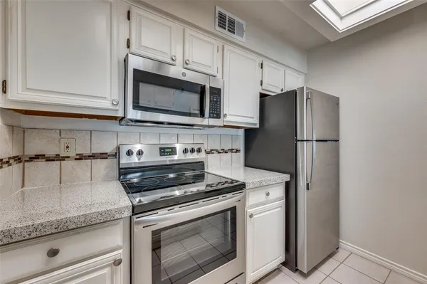 a kitchen with cabinets stainless steel appliances and a counter space