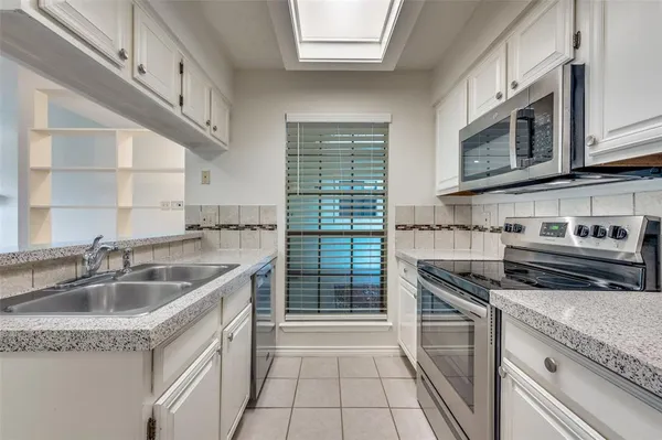 a kitchen with stainless steel appliances granite countertop a sink stove and cabinets