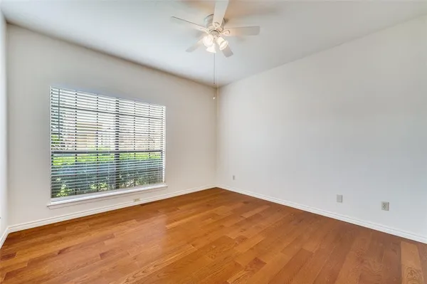an empty room with a window and a fan