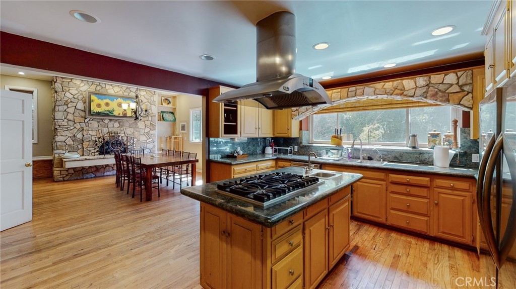 1248 Rocky Road Simi Valley, CA 93063 - Photo 14 of 71 a kitchen with stainless steel appliances granite countertop a stove top oven a sink with wooden cabinets and dining table