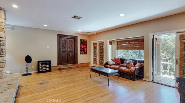 a dining room with wooden floor a chandelier a wooden table and chairs