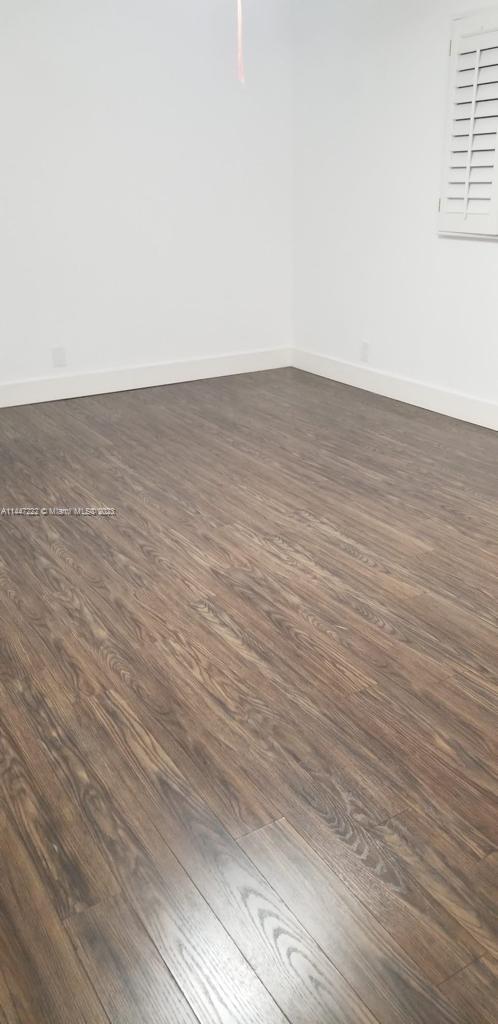 5790 Stirling Road, Unit 205 Hollywood, FL 33021 - Photo 21 of 28 an empty room with wooden floor and windows
