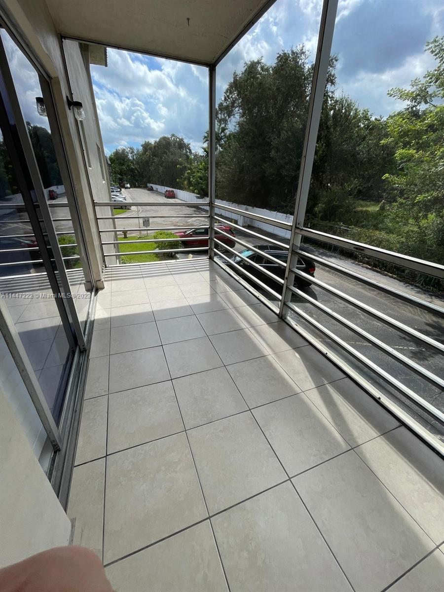 5790 Stirling Road, Unit 205 Hollywood, FL 33021 - Photo 3 of 28 a view of a balcony with wooden floor and iron stairs