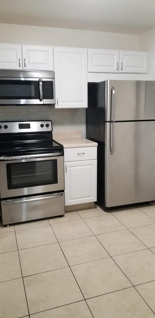 5790 Stirling Road, Unit 205 Hollywood, FL 33021 - Photo 5 of 28 a kitchen with a stove and a refrigerator