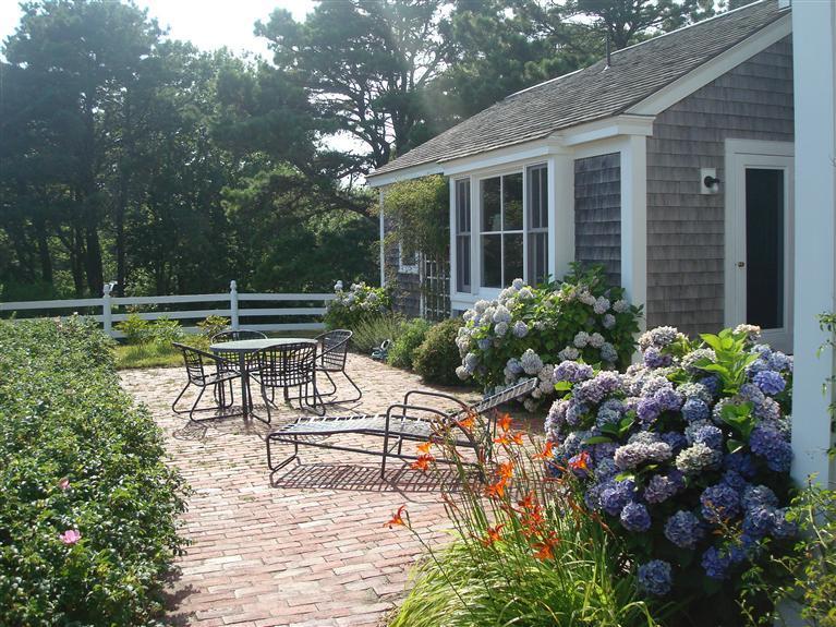 74 Sears Point Road Chatham, MA 02633 - Photo 12 of 16 a view of a patio with table and chairs and potted plants