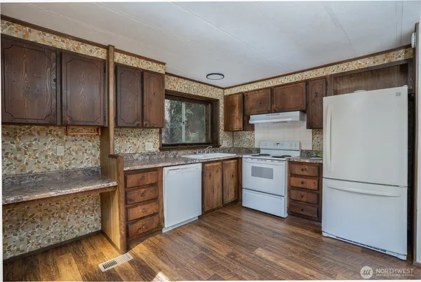 a kitchen with a refrigerator sink and cabinets